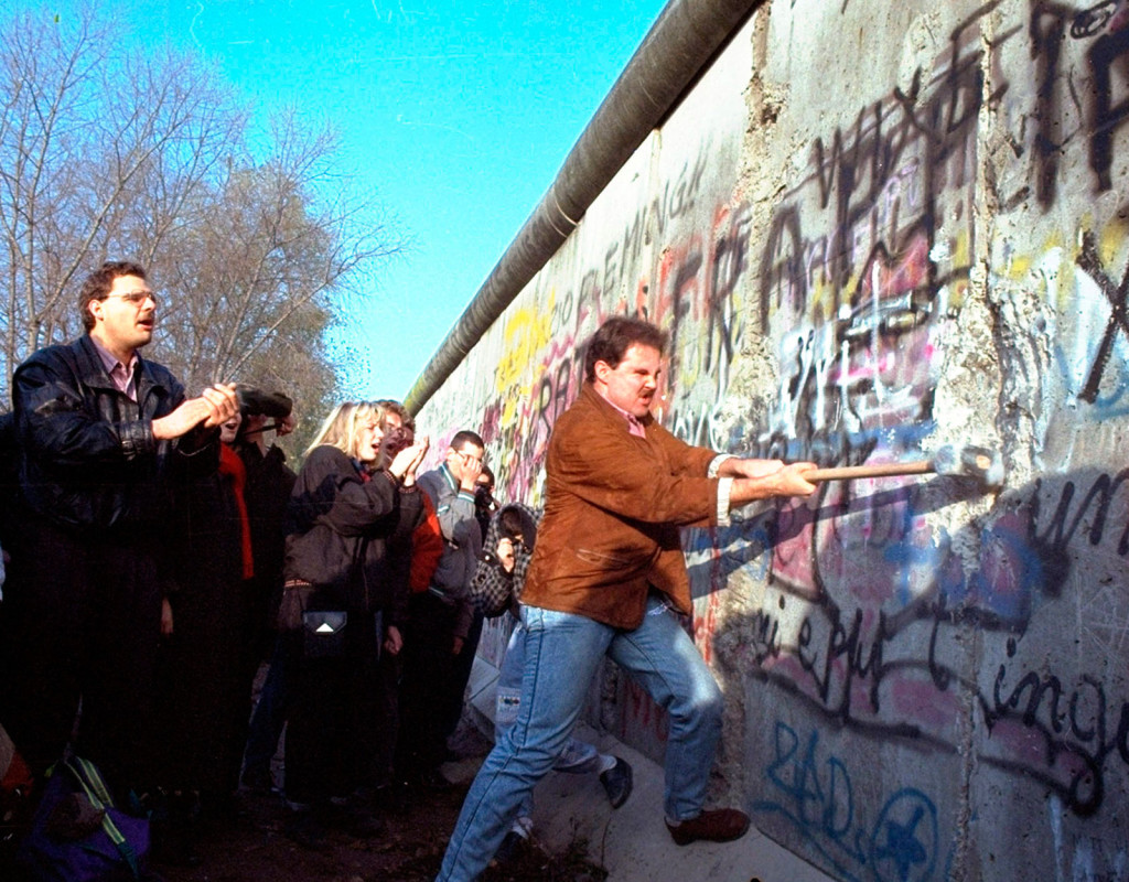 Berlinmuren rivs 1989 och världen jublar. En västberlinare slår med en slägga på muren vid Potsdamer Platz. 
Foto: AP
